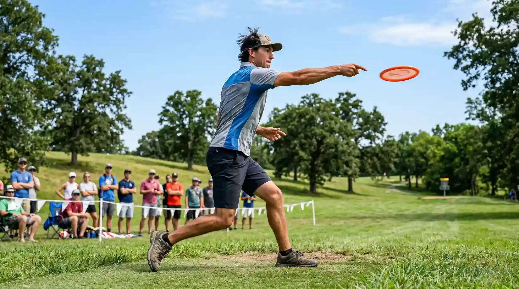 Disc golf spelare kastar under professionell turnering med publik